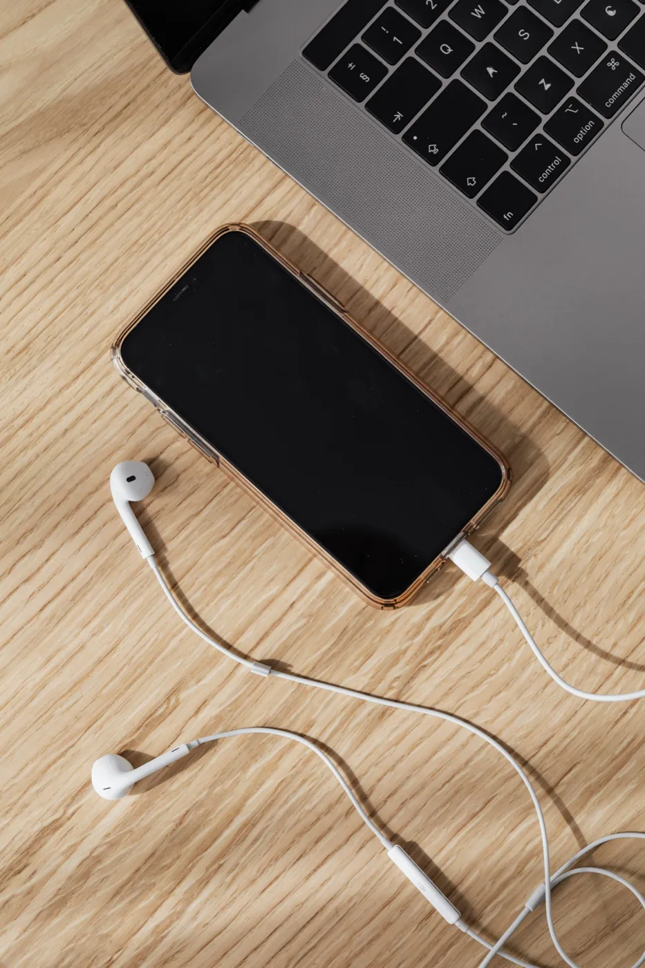 Escritorio con teléfono, audífonos y planta